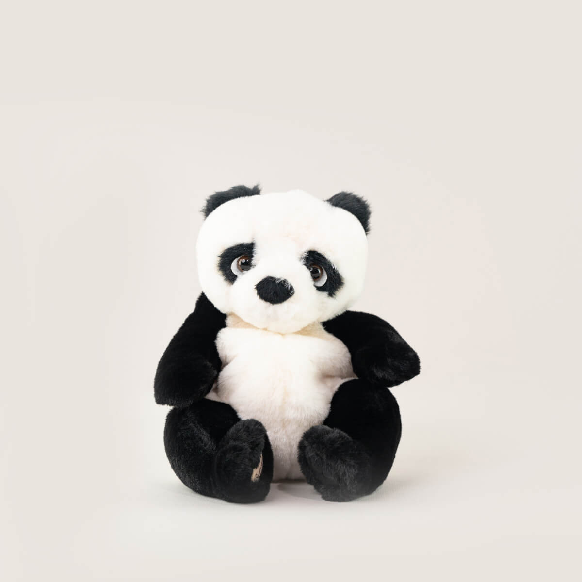 Der Bukowski Schweden Panda ist ein weiches Plüschtier mit schwarzem und weißem Fell. Dieser Panda sitzt aufrecht vor einem hellen Hintergrund und hat große schwarze Augen und einen sanften Ausdruck.