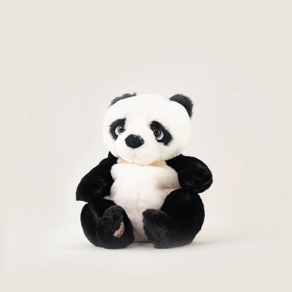 Der Bukowski Schweden Panda ist ein weiches Plüschtier mit schwarz-weißem Fell, großen runden Augen und einem niedlichen Ausdruck. Er sitzt aufrecht vor einem schlichten, hellen Hintergrund.